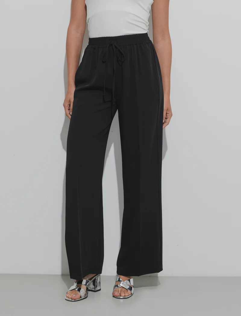 Pantalone palazzo con vita elasticizzata e coulisse regolabile. - Nero