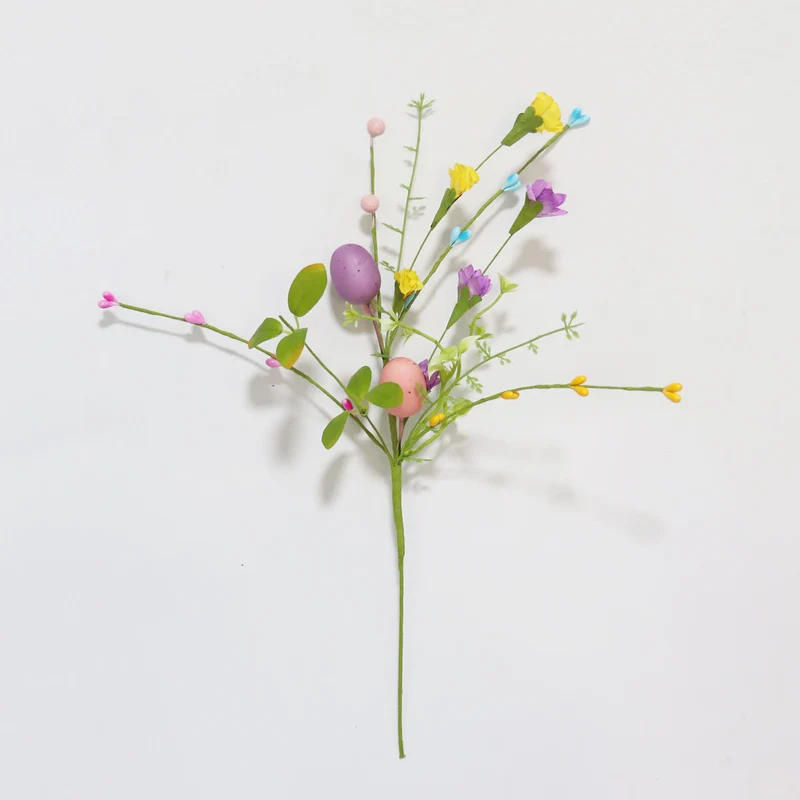 Ramo di uova di Pasqua con foglie verdi e fiori