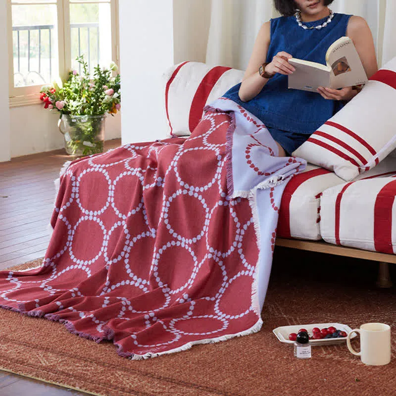 Coperta reversibile con motivo a cerchi e nappe
