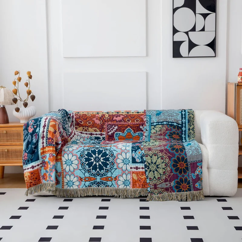 Coperta reversibile in cotone con nappe e stampa floreale blu in stile boho.